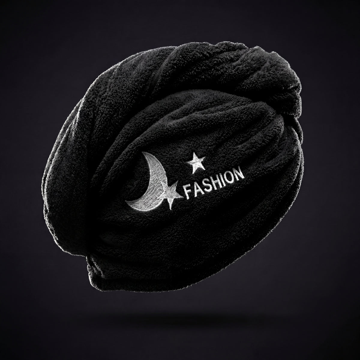The shaped hair towel showing its looped fabric and embroidered front detail